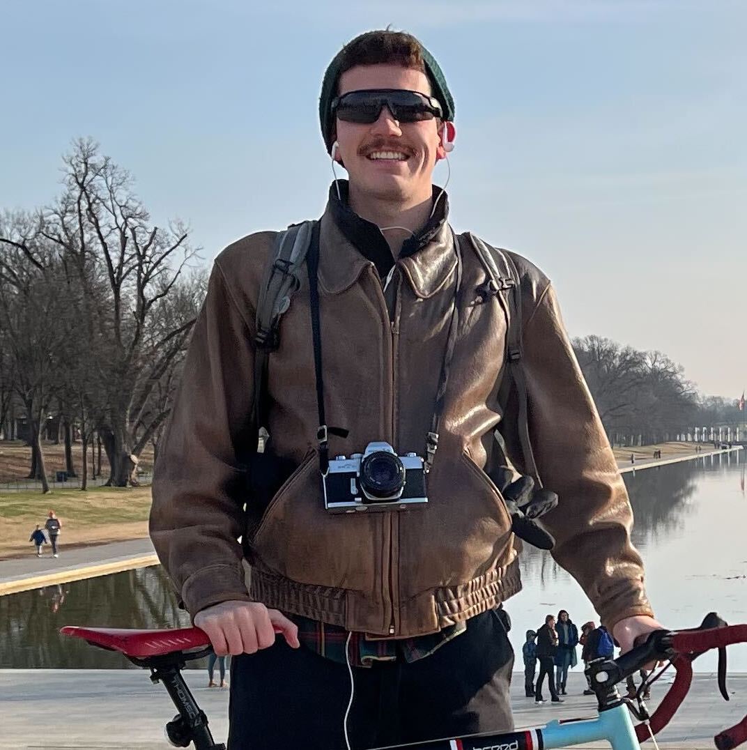 Student intern Tommy Duque poses with his bike.