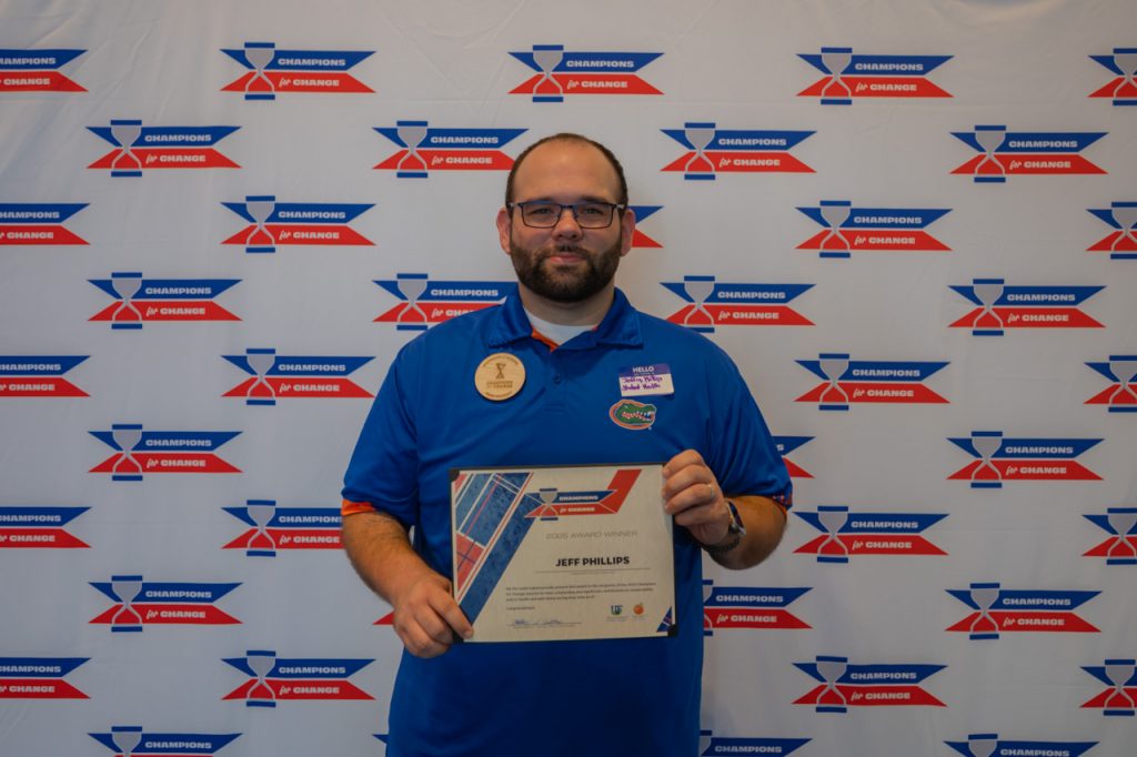 2025 Champions for Change Award Recipient, Jeff Phillips, pose with their award certificate.