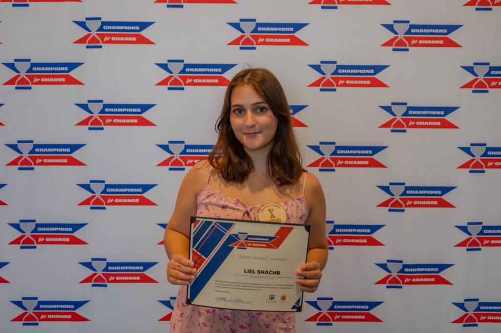 2025 Champions for Change Award Recipient, Liel Shachr, pose with their award certificate.