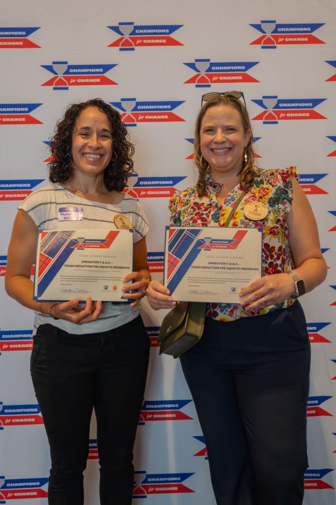 2025 Champions for Change Award Recipients, Operation T.R.A.P., pose with their award certificate.