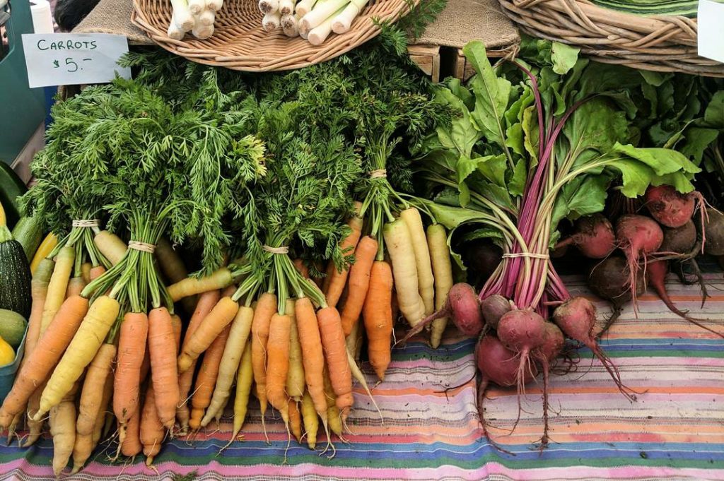 Beets and carrots on display in a farmers market