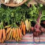 Beets and carrots on display in a farmers market