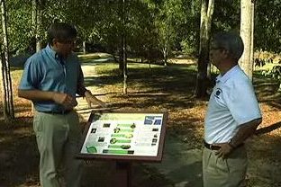 Two men looking at a sign on a nature trail