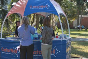 People stop by the GatorWell hut at the Sustainable Transportation Fair