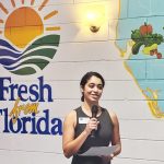 Gator Dining Services sustainability manager Kayla Caselli-Bido speaking in front of the "Fresh from Florida" mural