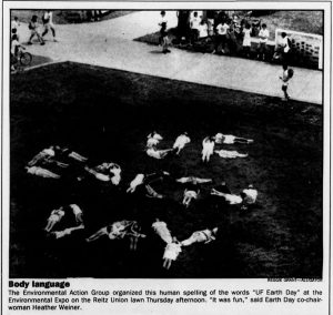 An elevated photo of students collectively creating the words "UF Earth Day" by lying down in the shape of letters on Reitz Lawn