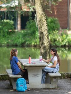 2 students enjoying time outside on the UF campus