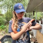 UF student and Green Gator of the Month Anna Mavrodieva holding an orange snake.