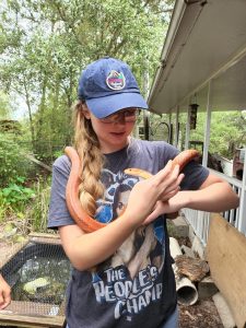 UF student and Green Gator of the Month Anna Mavrodieva holding an orange snake.