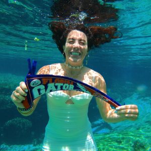 Mayssa Shalhoub, Green Gator of the Month, underwater showing school spirit. 