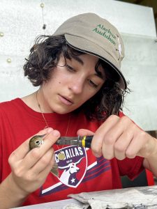 UF student Brynn Fricke with a bird at the banding lab.